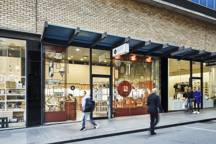 An exterior photograph of e.g.etal jewlery story on Little Collins Street, Melbourne. Pedestrians pass a large, illuminated shop front that's full of beautiful jewlery. 